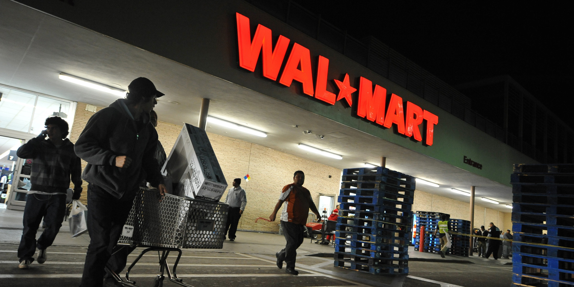 Shoppers wheel their purchases out of a Wal-Mart store in Los Angeles, California, before dawn on Black Friday, November 27, 2009. The annual sales bonanza is held one day after the Thanksgiving holiday. AFP PHOTO / Robyn Beck (Photo credit should read ROBYN BECK/AFP/Getty Images)