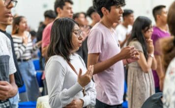 Jovens rezando em uma igreja