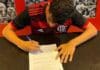 Foto do jovem Levy Dias assinando com o Flamengo