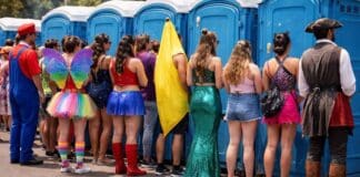 Foto de foliões perto de banheiros químicos