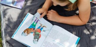 Criança lendo livro infantil
